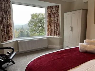 a bedroom with a large window and a large bed at Three Peaks in Braithwaite