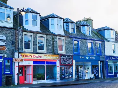 a group of buildings on a city street at Cosy apartment in popular harbour town in Kirkcudbright