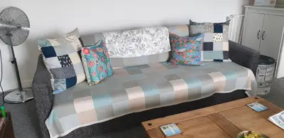 a couch with pillows on it in a living room at Cosy apartment in popular harbour town in Kirkcudbright