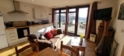 a living room with a couch and a table at Wastwater Cottage on The Big 