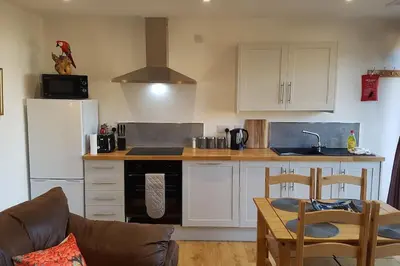 a kitchen with white cabinets and a stove top oven at Wastwater Cottage on The Big 