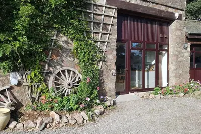a stone building with a wooden wheel on the side of it at Wastwater Cottage on The Big 