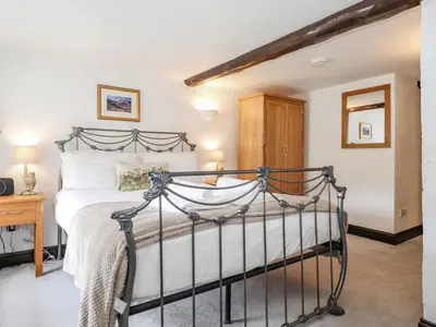 a bedroom with a bed with a metal frame at Woodloft Cottage in Elterwater