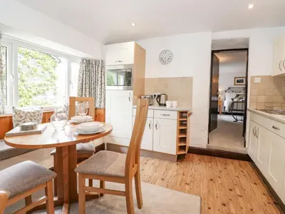 a kitchen with a table and a dining room at Woodloft Cottage in Elterwater