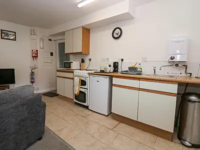 a kitchen with white cabinets and a counter top at Newfield Apartment 2 in Broughton in Furness