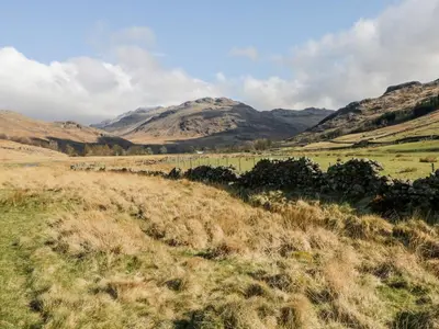 a field of grass with mountains in the background at Newfield Apartment 2 in Broughton in Furness