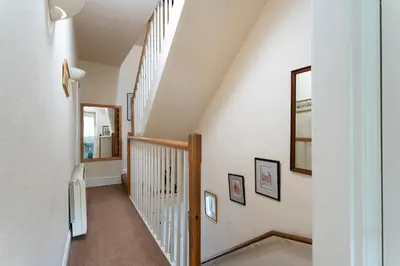 a staircase in a home with white walls and wooden railings at Oak Cottage Chapel Stile in Chapel Stile