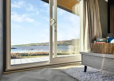 a room with a large window with a view of the ocean at Sandgreen Caravan Park in Girthon
