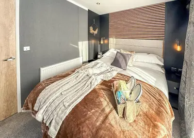 a bedroom with a large bed with two baskets on it at Sandgreen Caravan Park in Girthon