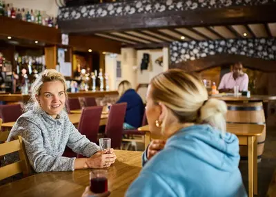 two women sitting at a table in a restaurant at Lyons Manor House in Maryport