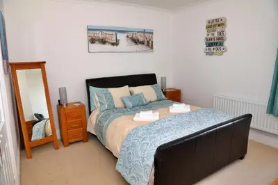 a bedroom with a bed and a mirror at Finest Retreats - Glendale in Skinburness