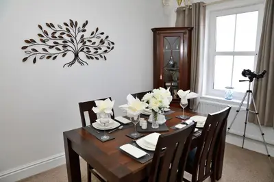 a dining room table with chairs and flowers on it at Finest Retreats - Glendale in Skinburness