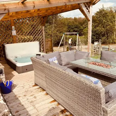 a patio with a couch and a hot tub at The Dairy in Castle Douglas
