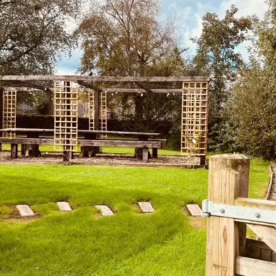 a wooden park bench in a field of grass at The Dairy in Castle Douglas