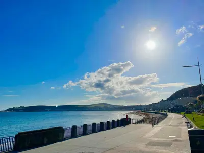 a view of a beach with the sun in the sky at Promenade House in Douglas