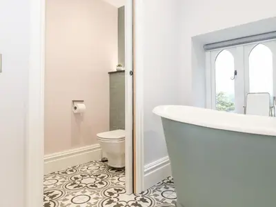 a bathroom with a tub and a toilet at Eller Close House in Ambleside