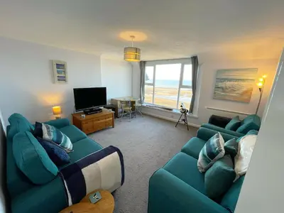 a living room with two blue couches and a television at 14 Burnett House by Prestige Properties SA in Seascale