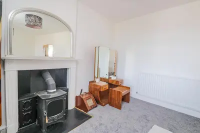 a living room with a fireplace and a mirror at 3 Clarks Terrace in Maryport