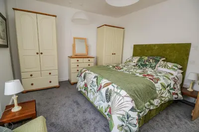 a bedroom with a bed and a dresser and a mirror at 3 Clarks Terrace in Maryport