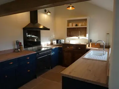a kitchen with blue cabinets and a stove top oven at Caldhu Cottage in Holmrook