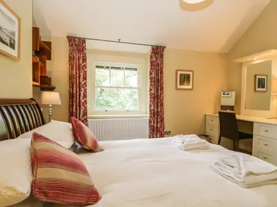a bedroom with a bed and a desk and a window at Scale Force in Keswick