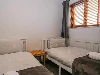 a small room with two beds and a window at Ravenglass Retreat in Ravenglass