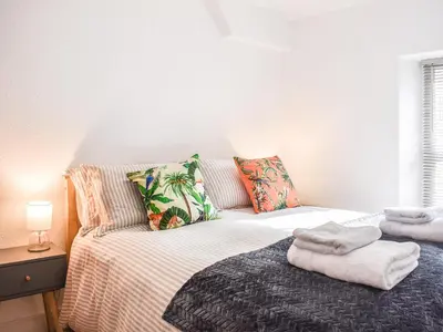 a bedroom with a bed with towels on it at Riverside Cottage in Keswick