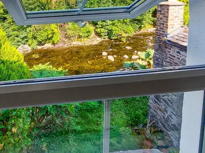 an open window with a view of a garden at Riverside Cottage in Keswick