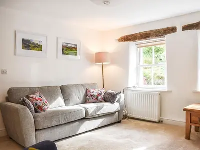 a living room with a couch and a window at Riverside Cottage in Keswick