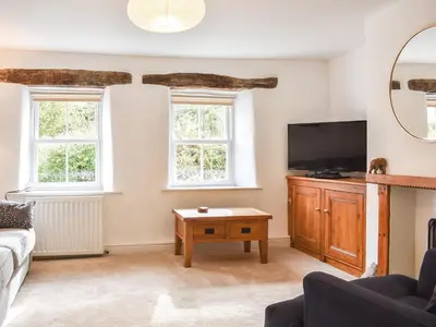 a living room with a tv and a couch at Riverside Cottage in Keswick