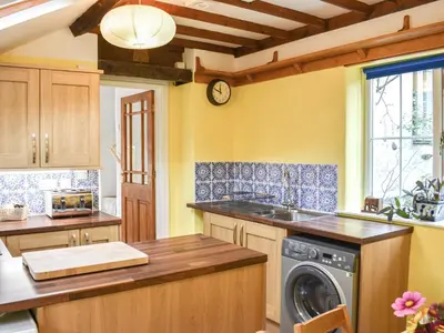 a kitchen with a washer and dryer on a counter at Riverside Cottage in Keswick