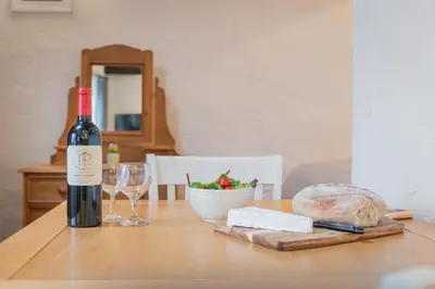 a bottle of wine and a glass on a table at Cottage 6 Studio Mews in Keswick