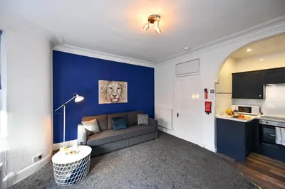 a living room with a couch and a blue wall at The Wee Lion in Troon