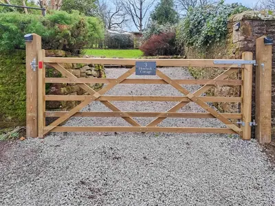 a gate to a garden with a sign on it at Howbeck Cottage in Hesket Newmarket