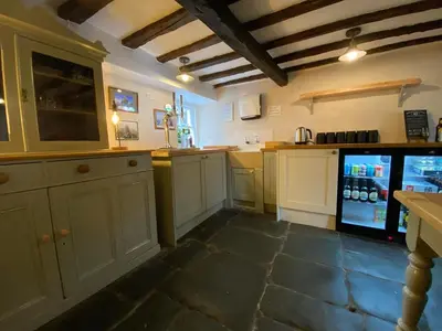 a kitchen with white cabinets and a refrigerator at Seatoller House in Borrowdale Valley