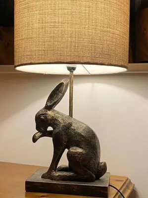 a statue of a dog sitting on a table next to a lamp at Courtyard Cottage in Lockerbie