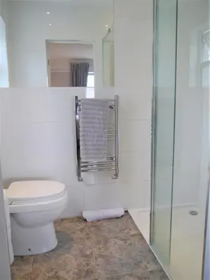 a bathroom with a toilet and a glass shower at Glaisters Farmhouse in Castle Douglas