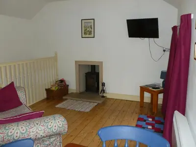 a living room with a couch and a tv at The Old Map Shop in Wigton