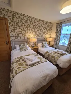 a hotel room with two beds and a window at Royal Oak Braithwaite in Keswick