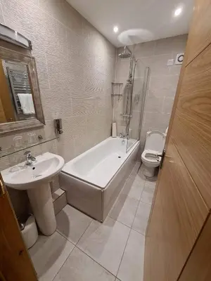 a bathroom with a tub and a sink and a toilet at Royal Oak Braithwaite in Keswick