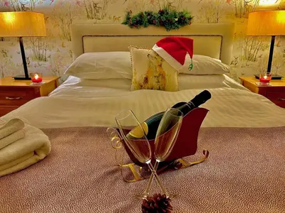 a bottle of wine in a cart on a bed at Royal Oak Braithwaite in Keswick