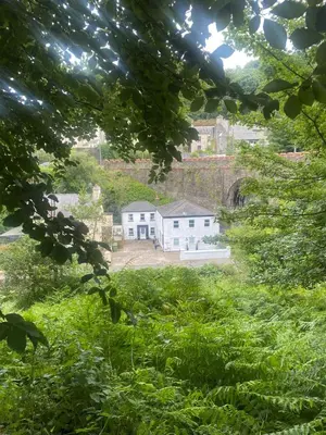a view of a house in a field of grass at The Workshop, Bridge House in Laxey