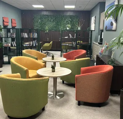 a waiting room with tables and chairs in a library at Bowscale Suite in Penruddock