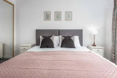 a bedroom with a large bed with two pillows at No27 The Barclay - Donnini Apartments in Kilmarnock