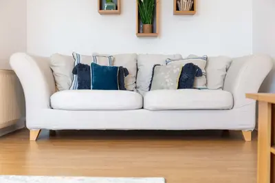 a white couch with pillows on it in a living room at No27 The Barclay - Donnini Apartments in Kilmarnock