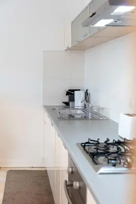 a white kitchen with a stove and a sink at No27 The Barclay - Donnini Apartments in Kilmarnock