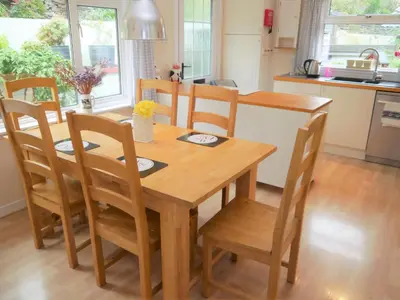 a wooden table and chairs in a kitchen at Arakhova in Kirkcudbright