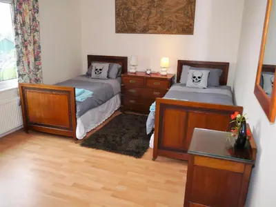 a bedroom with two beds and a desk and a window at Arakhova in Kirkcudbright