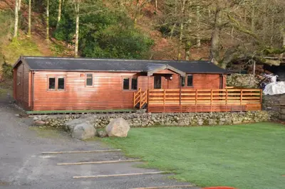 a wooden train cabin on a stone wall at Woolpack Lodge in Holmrook