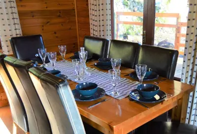 a wooden table with chairs around it with glasses on it at Woolpack Lodge in Holmrook